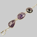 Bracelet with purple teardrop-shaped stones on a beige background