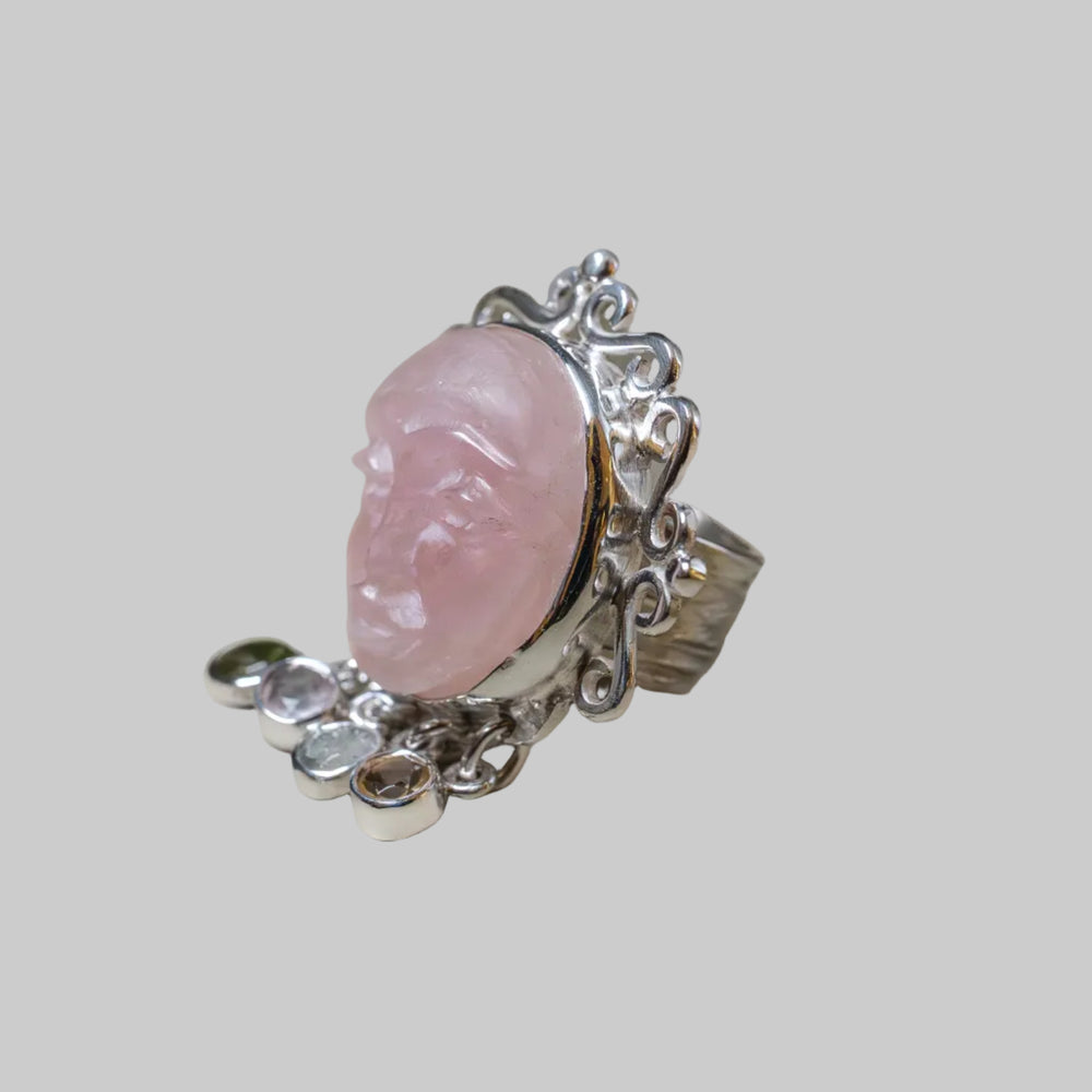 Silver ring with a pink stone on a beige background