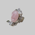 Silver ring with a pink stone on a beige background