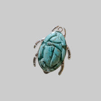 Turquoise scarab ring on a gray background