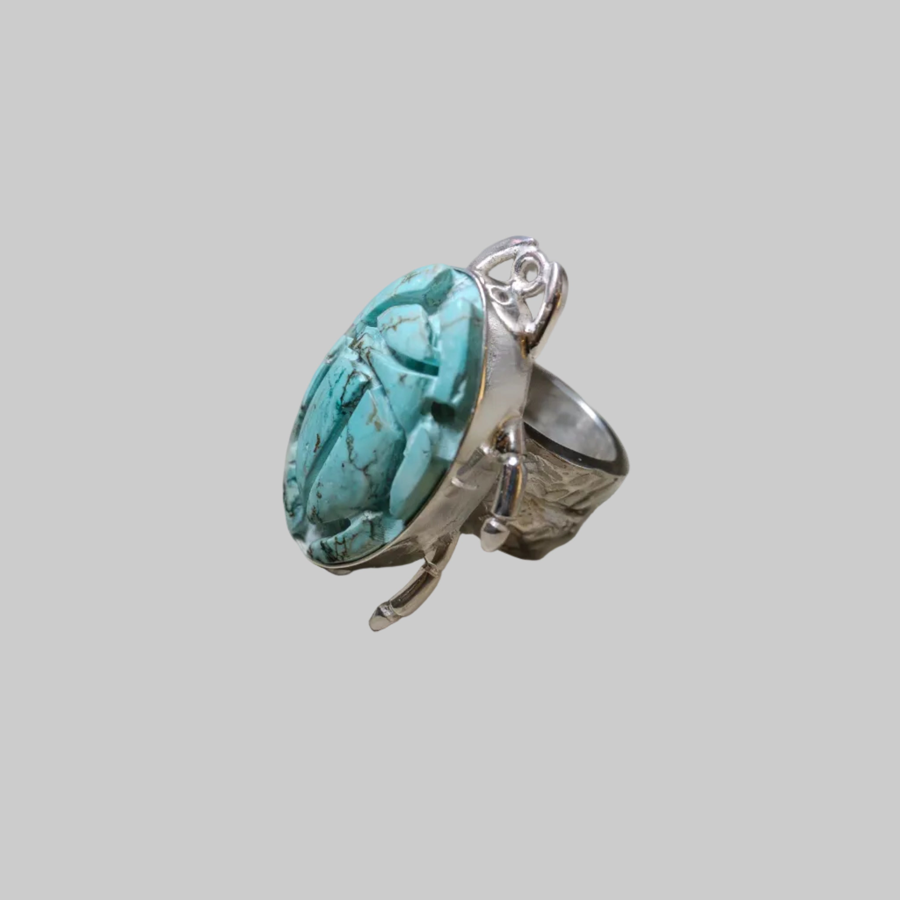 Silver ring with a large turquoise stone on a light gray background