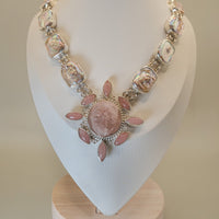 Necklace with pink and silver beads on a white mannequin bust.
