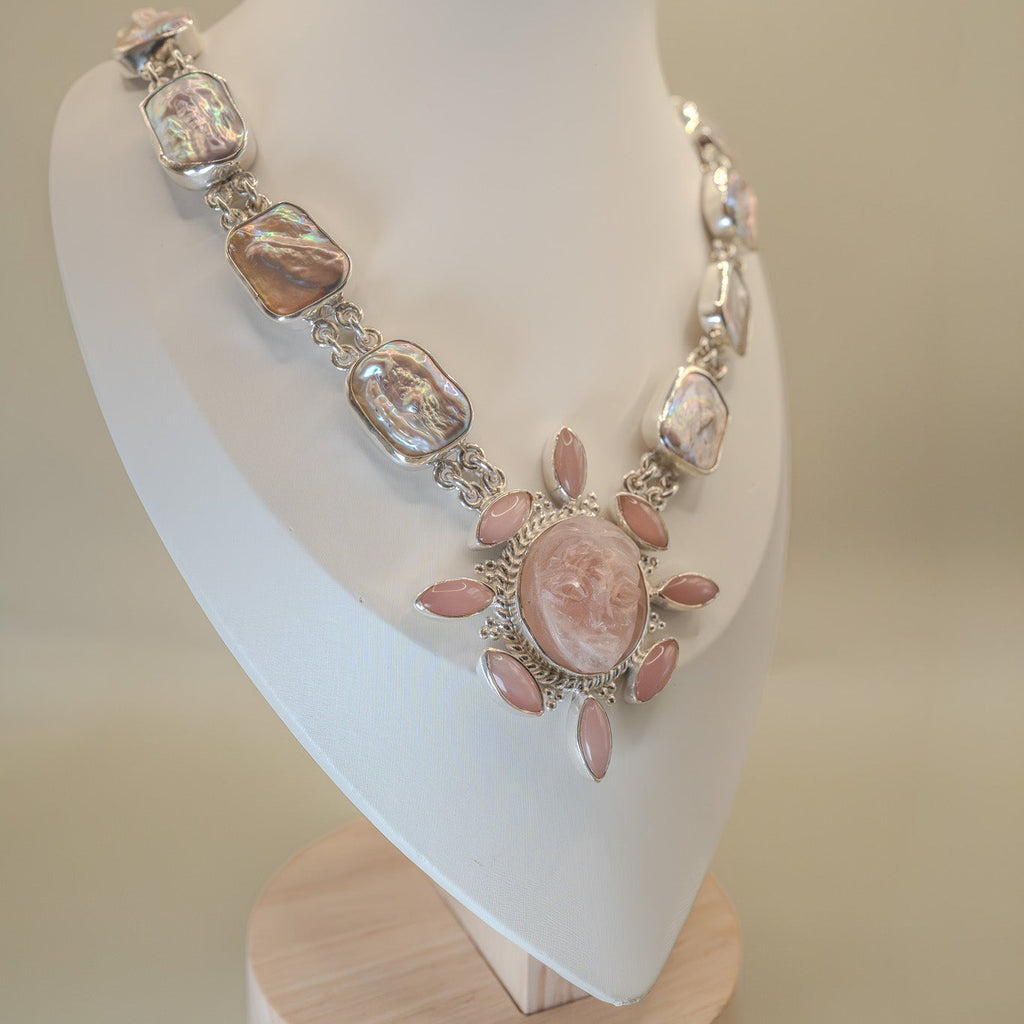 Necklace with pink and silver stones on a mannequin bust against a beige background
