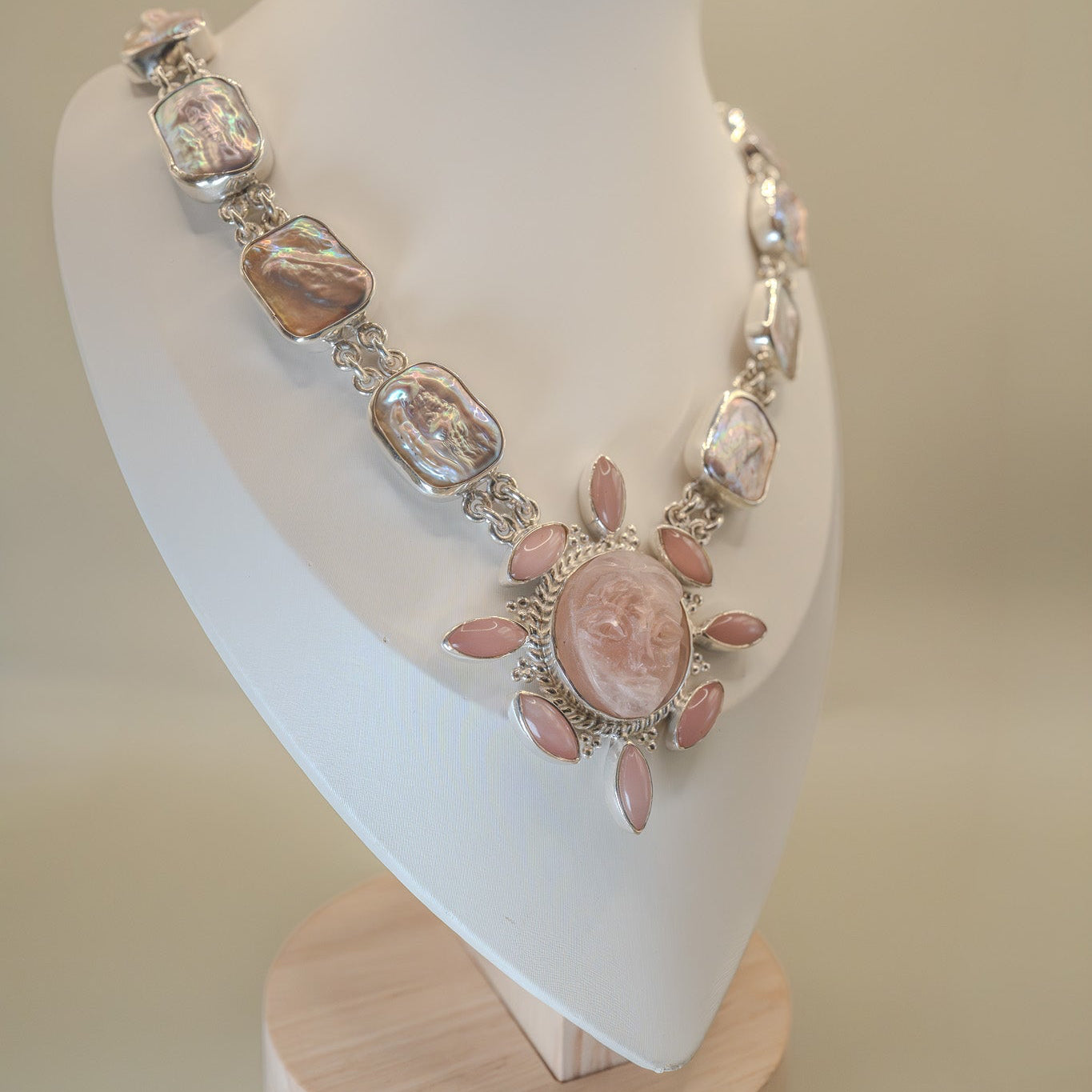 Necklace with pink and silver stones on a mannequin bust against a beige background