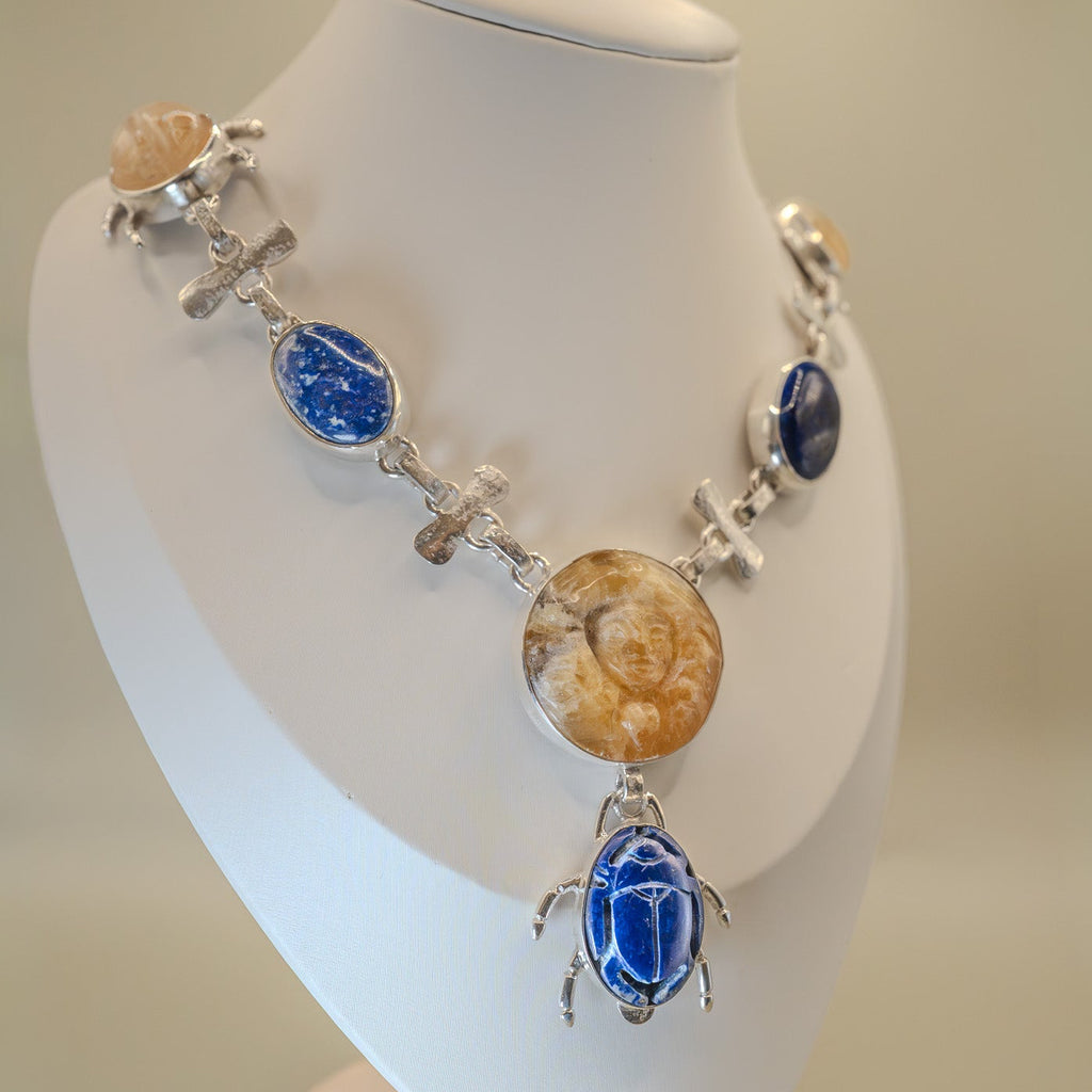 Necklace with blue and brown stones on a mannequin bust against a beige background