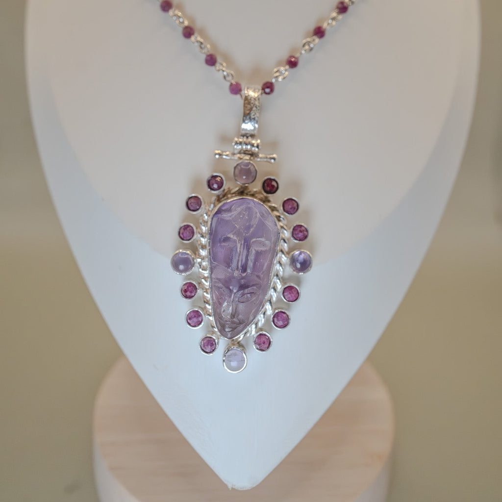 Necklace with a purple pendant on a mannequin bust against a neutral background