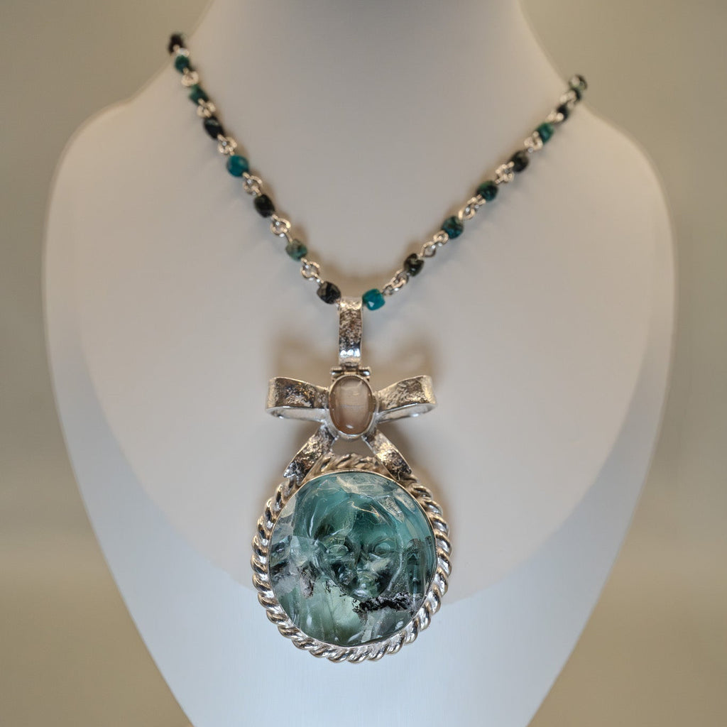 Necklace with a pendant on a mannequin bust against a neutral background