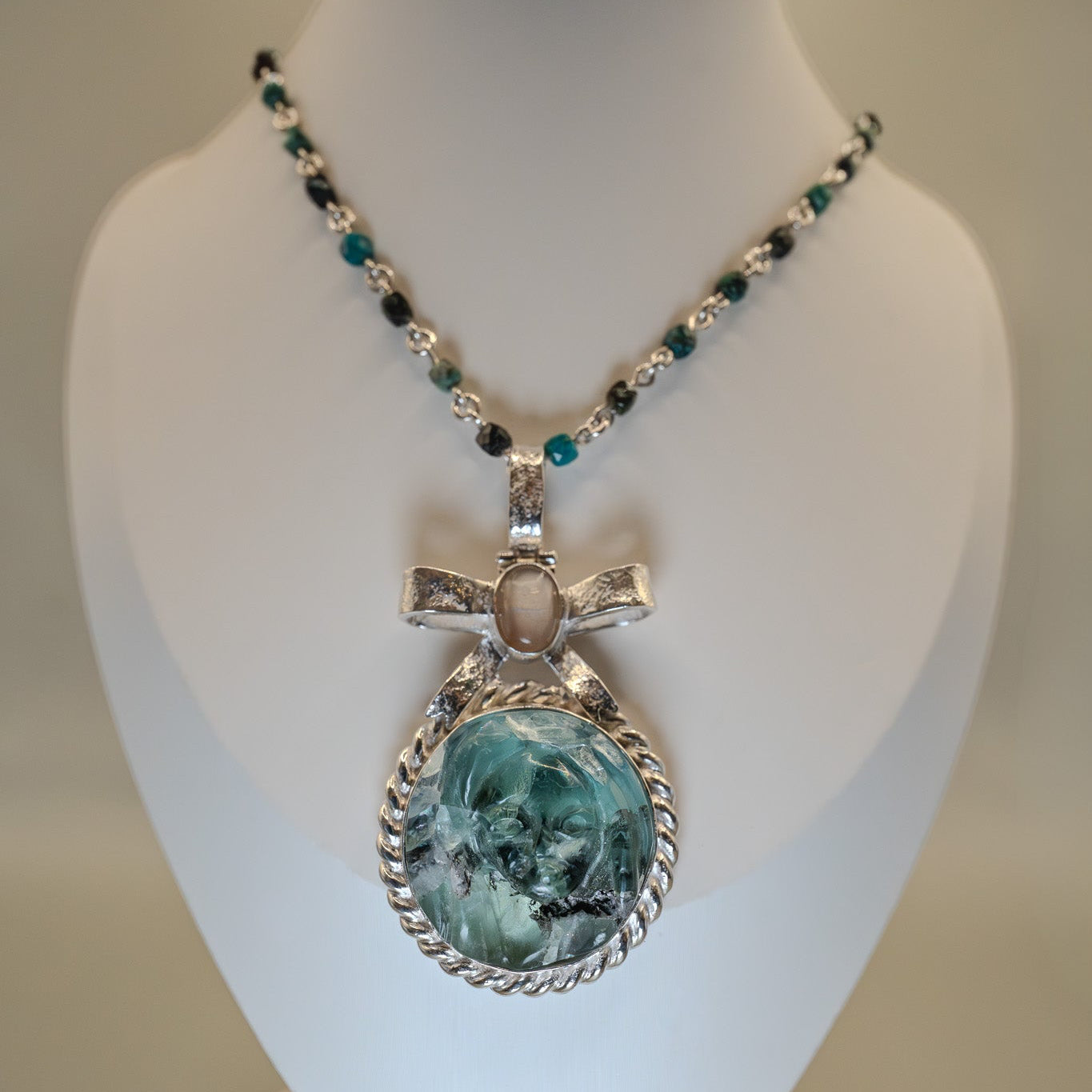 Necklace with a pendant on a mannequin bust against a neutral background
