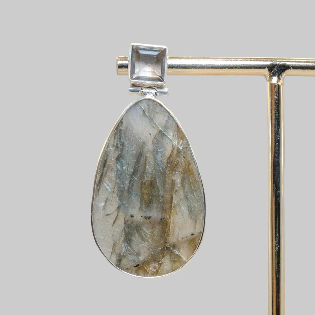 Jewelry earring with stone and silver frame on a neutral background