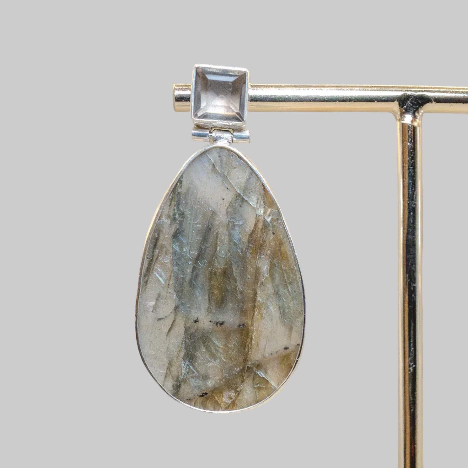 Jewelry earring with stone and silver frame on a neutral background