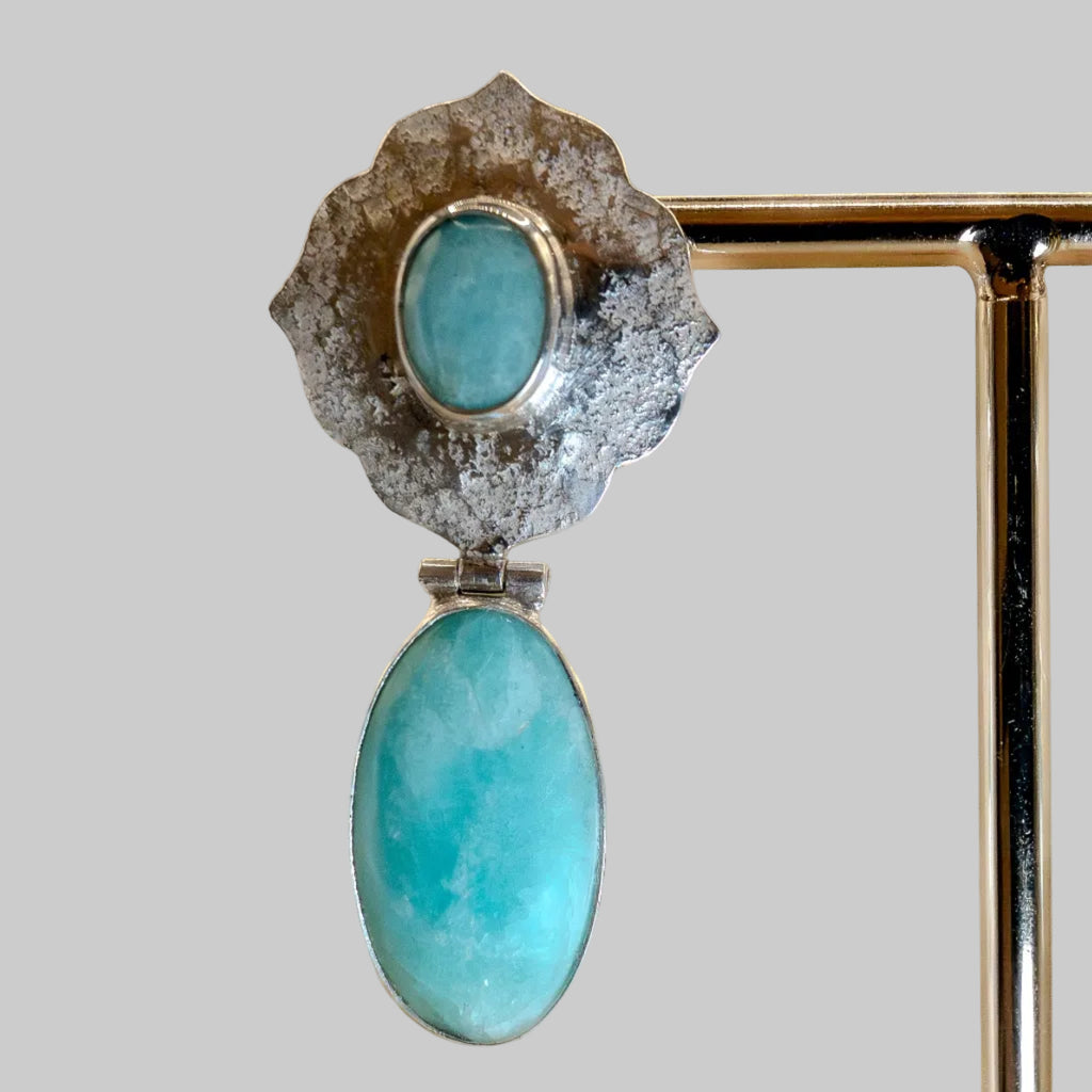 Jewelry with turquoise stones and silver or gold setting on a beige background