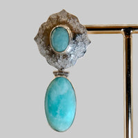 Jewelry with turquoise stones and silver or gold setting on a beige background