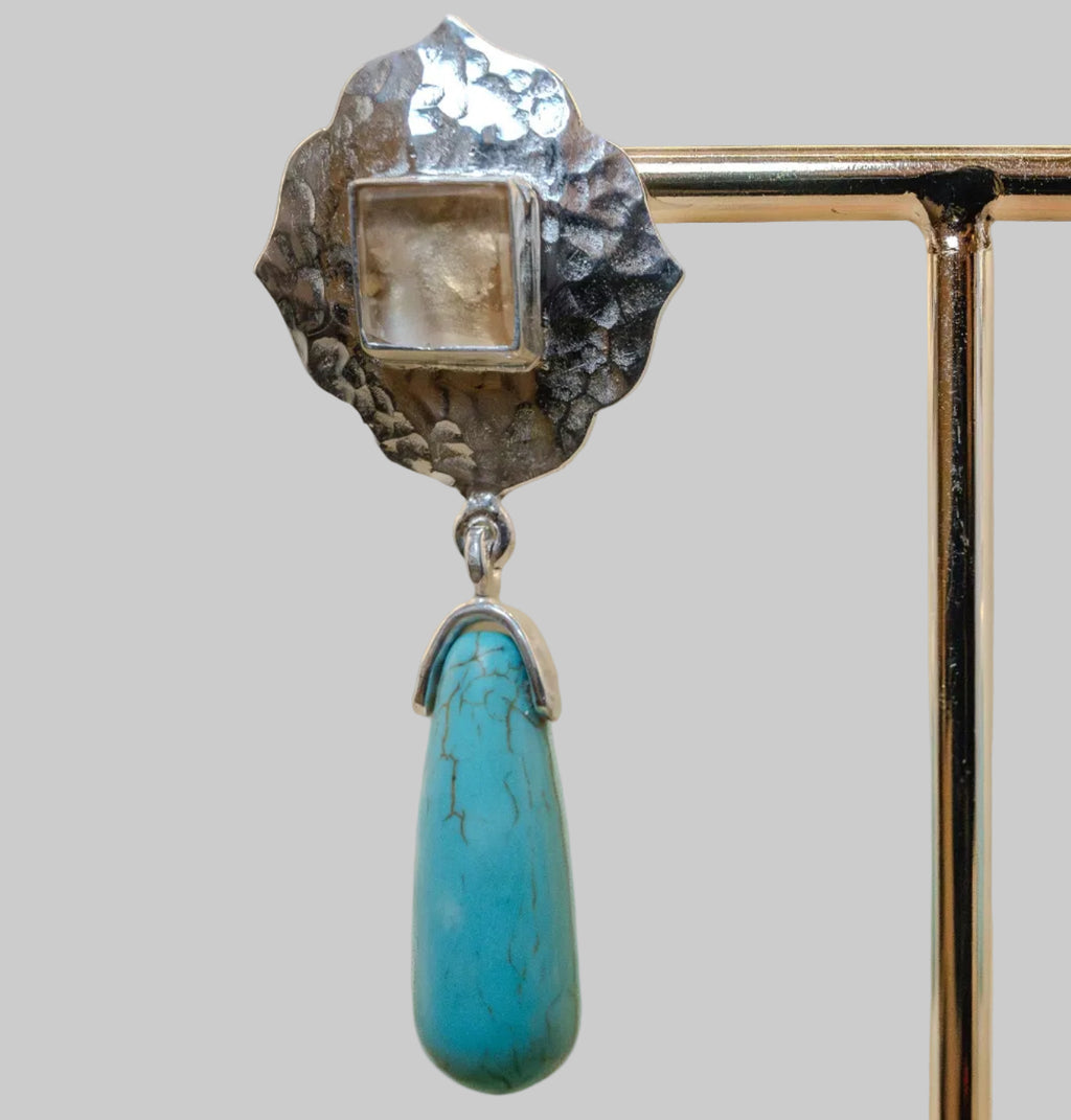 Jewelry with a turquoise stone and silver design on a beige background