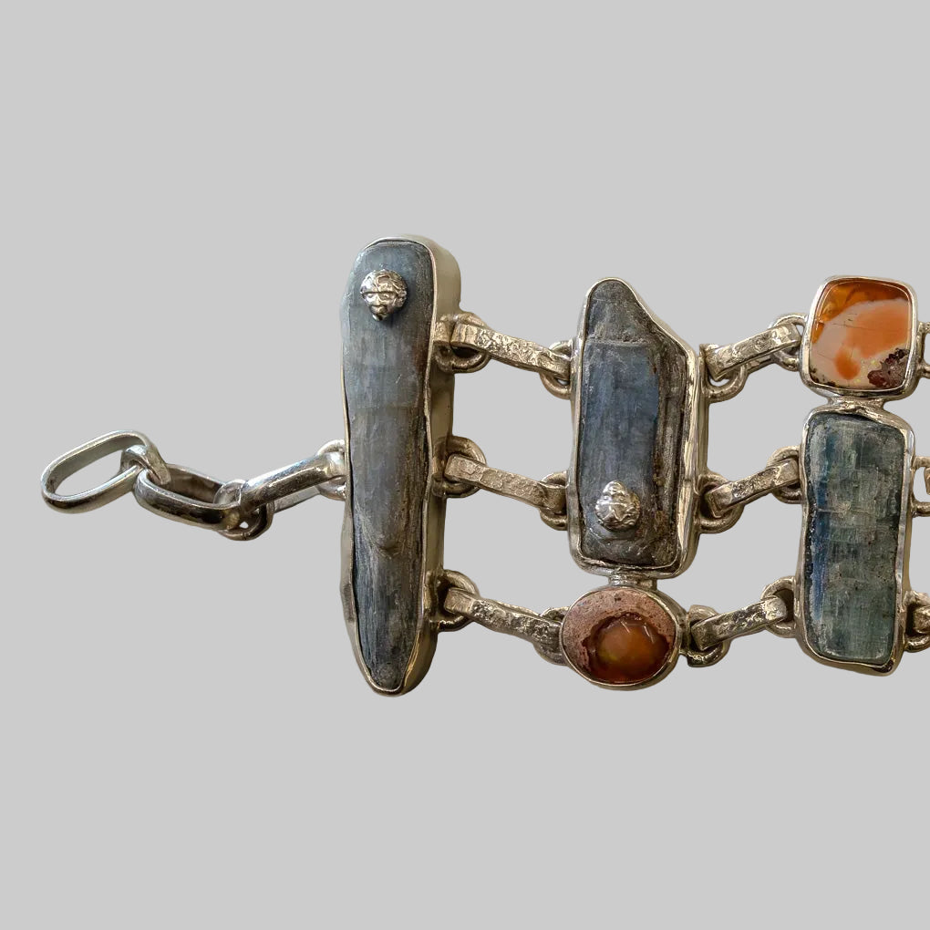 Silver bracelet with embedded stones on a neutral background