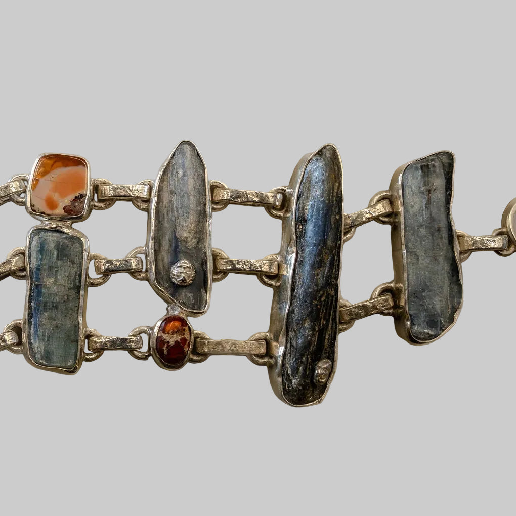 Silver bracelet with embedded stones on a neutral background