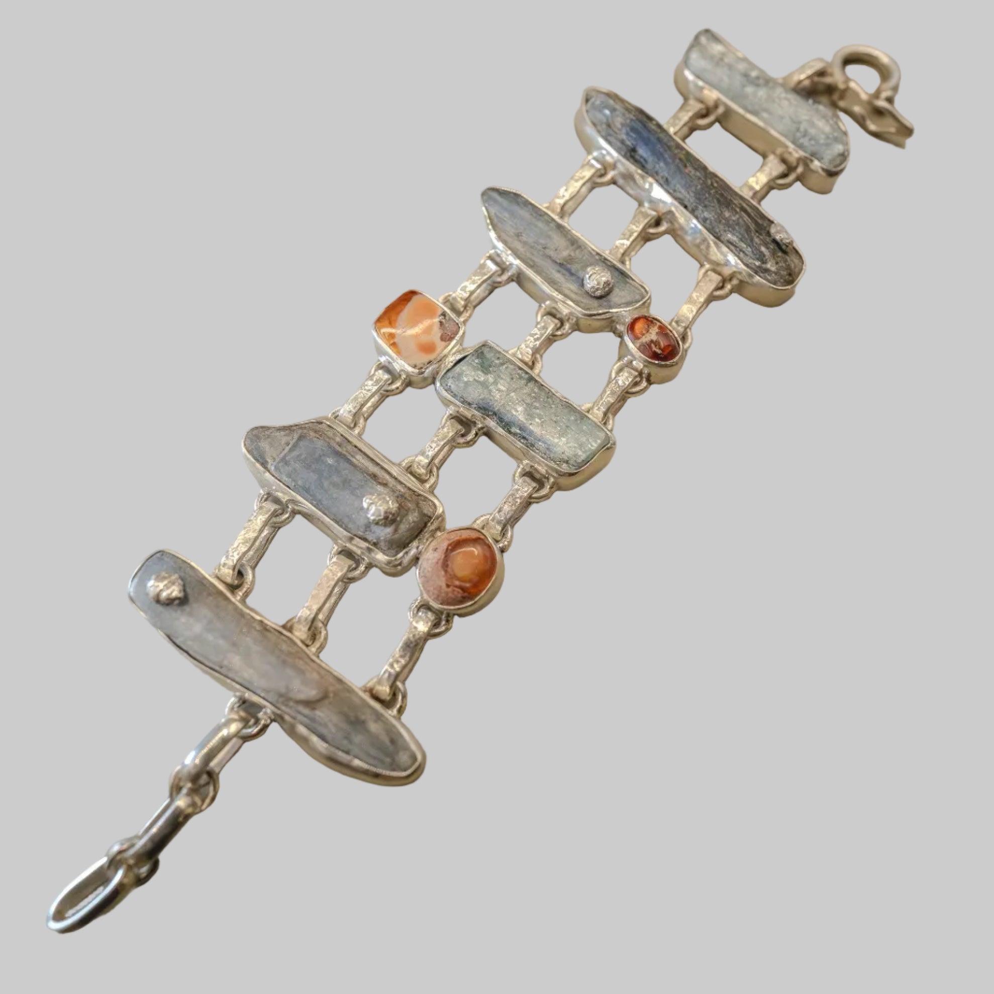 Silver bracelet with embedded stones on a beige background