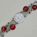 Silver bracelet with red gemstones on a gray background