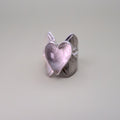 Silver heart-shaped ring on a light gray background