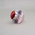 Silver ring with a red stone on a light gray background